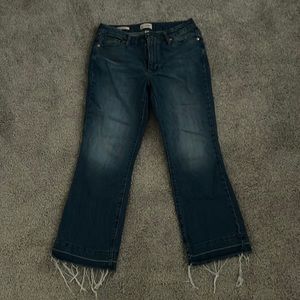 Denim jeans with frayed bottoms